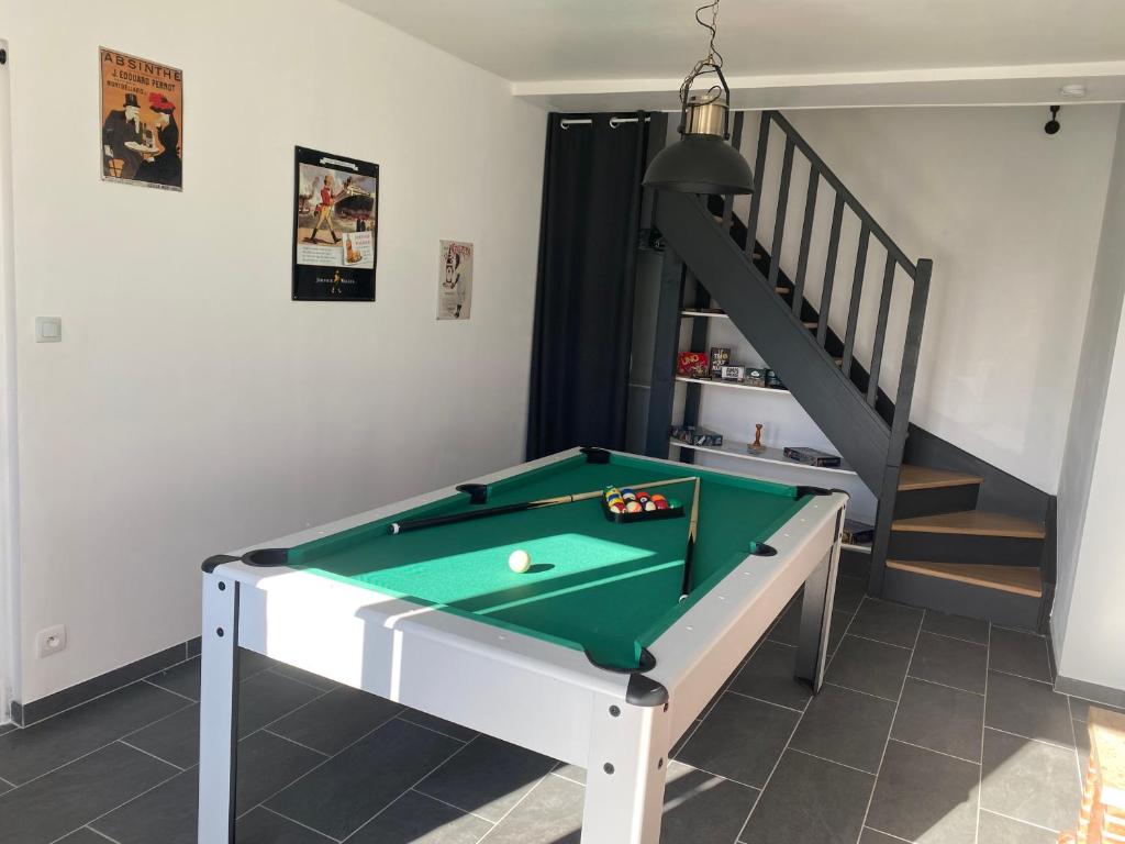 - un billard dans une pièce avec un escalier dans l'établissement La Grande maison du bourg, à Mareuil-sur-Cher
