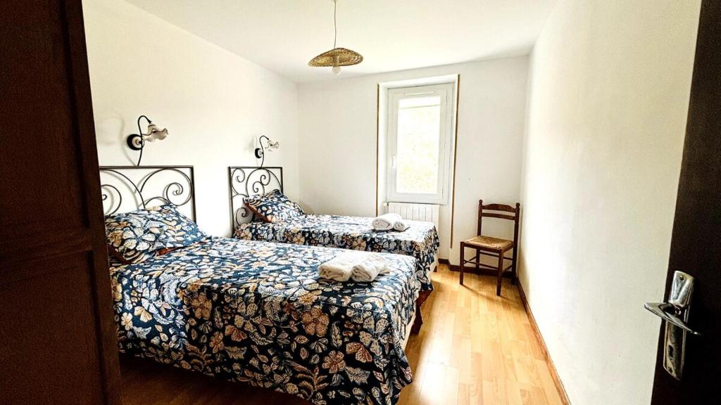 a bedroom with two beds and a window at Maison sur la Route du Mont Ventoux in Bédoin