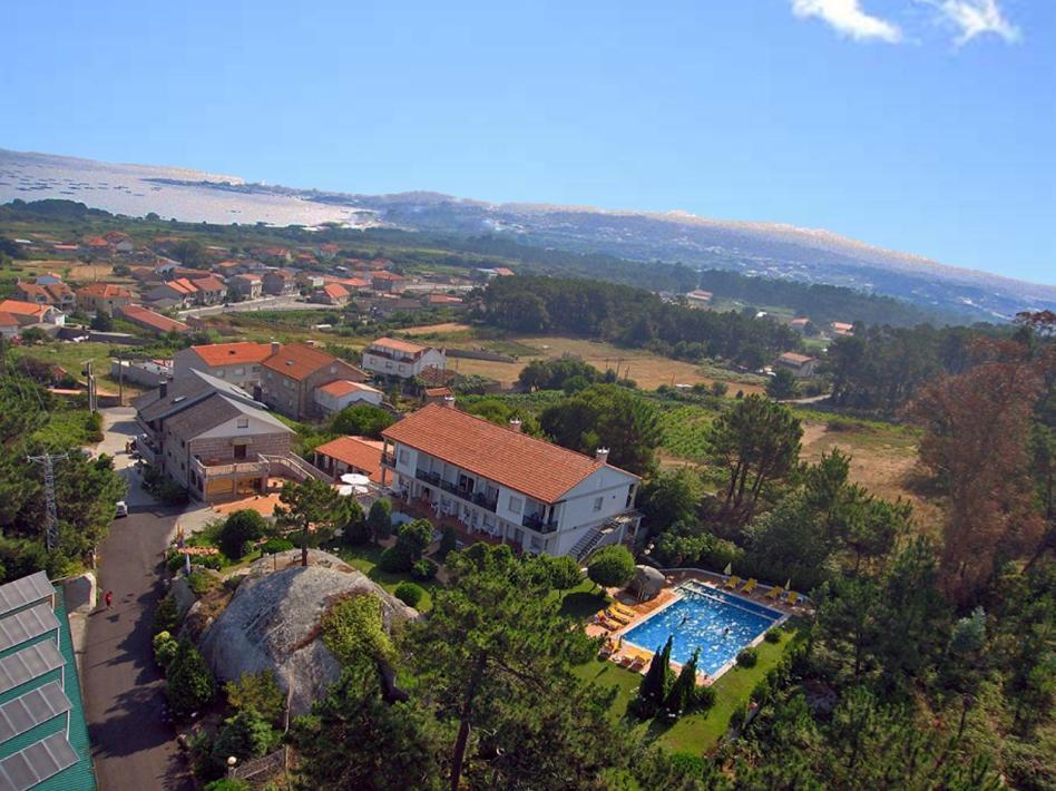 uma vista aérea de uma casa e de uma piscina em Hotel & Apartamentos Cons da Garda em San Vicente de O Grove