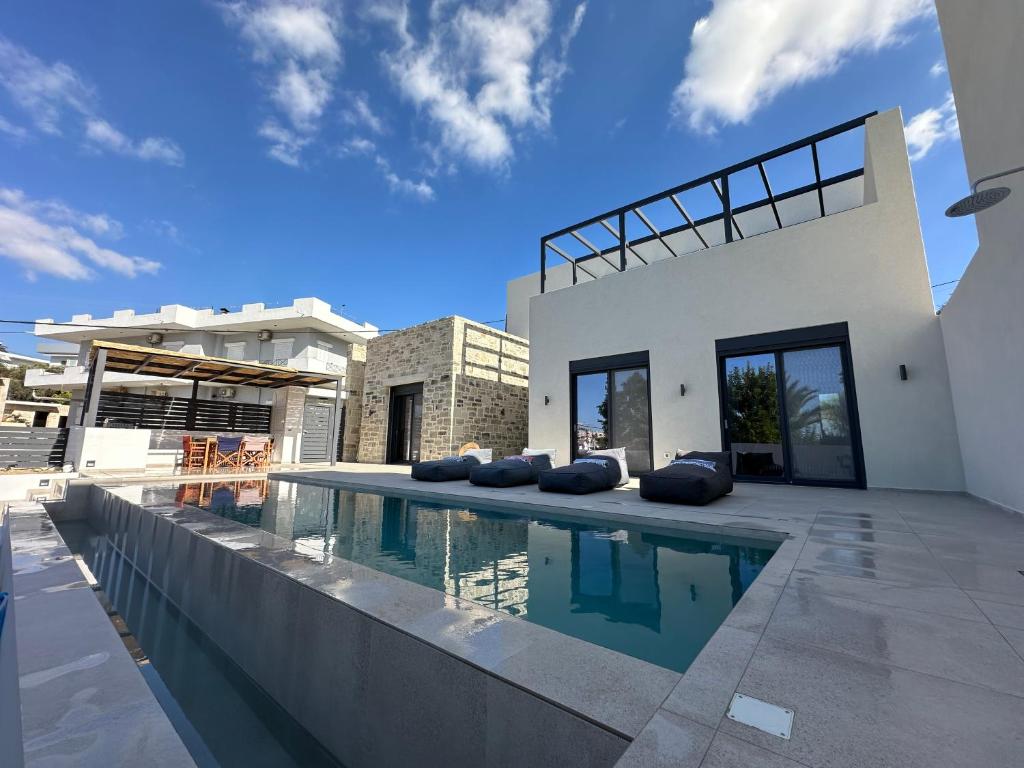a house with a swimming pool in front of a house at Villa SAMBA in Kamilari