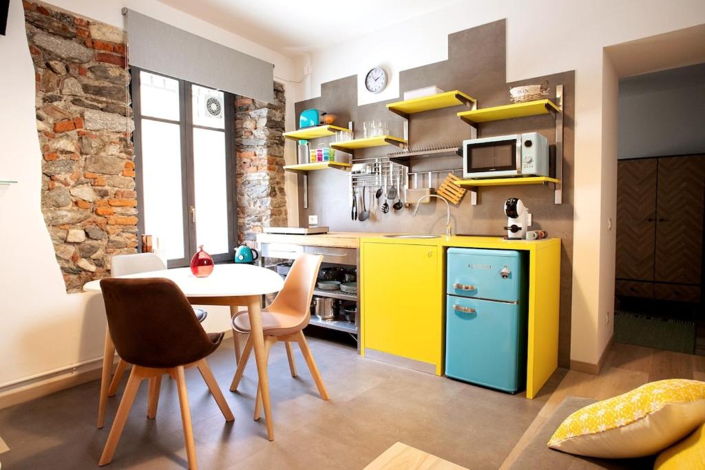 a kitchen with a table and a yellow refrigerator at Baby Art Apartment in Arona