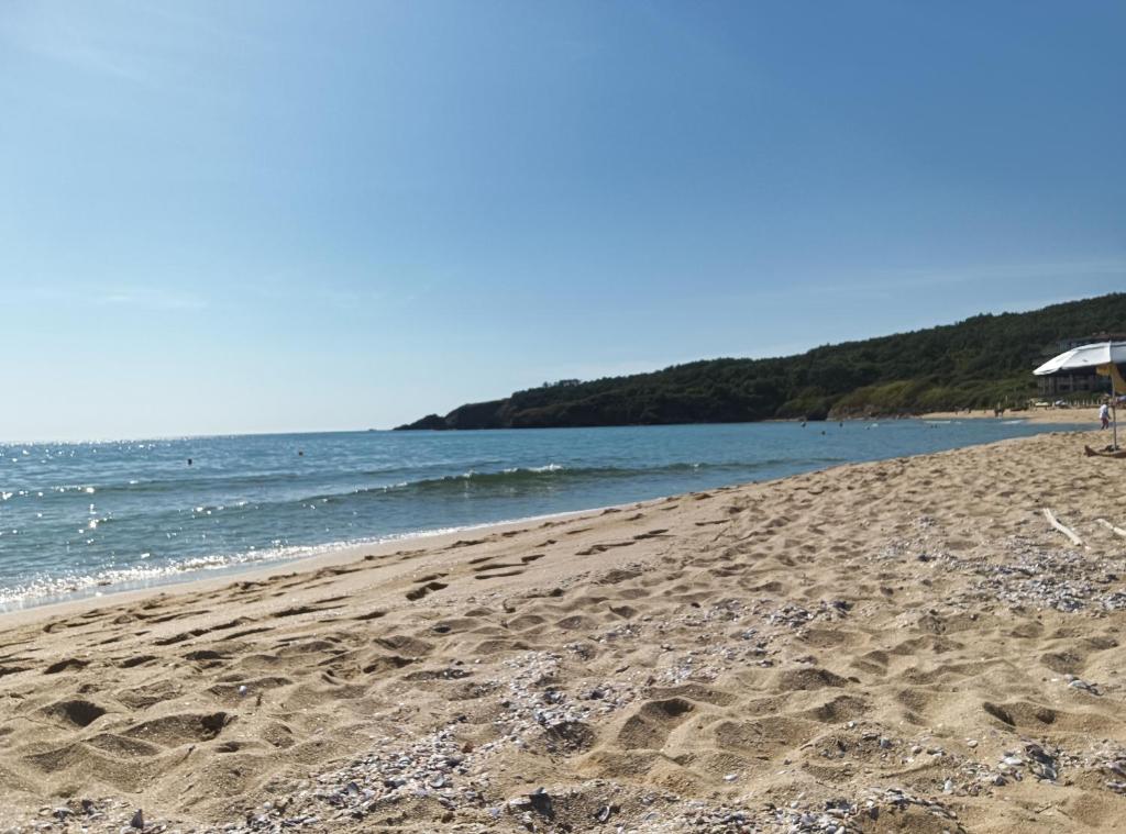a beach with footprints in the sand and the water at Studio Quatro - South Pearl - Sozopol in Sozopol
