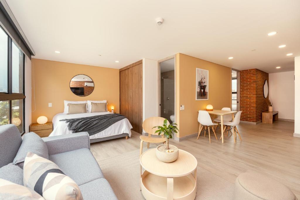 a bedroom and living room with a bed and a couch at Kyux Studios by MOME in Medellín