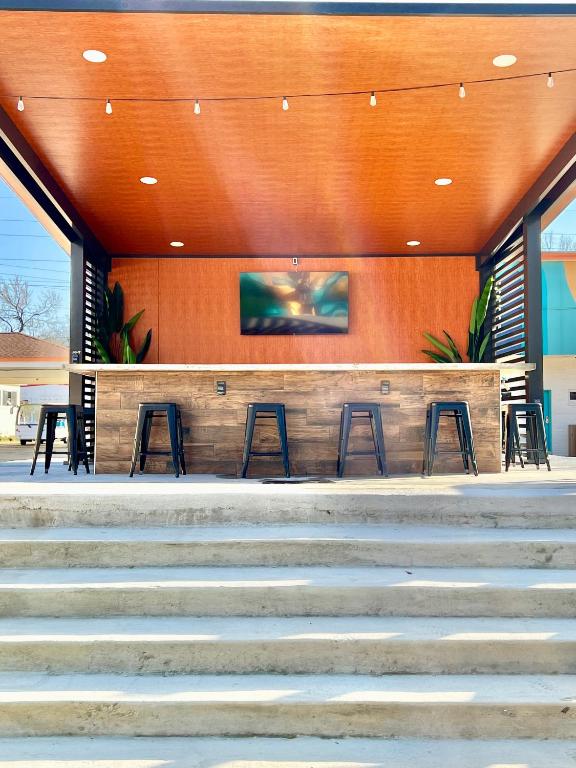 a bar with stools in front of a building at Far Out Motel in Starkville