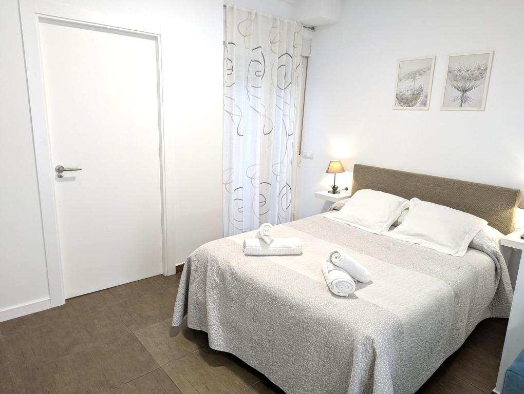 um quarto com uma cama com duas toalhas em Estudios en la playa em Valência