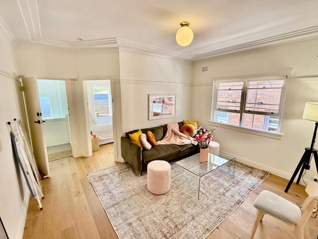 een woonkamer met een bank en een glazen tafel bij Bondi Bungalow in Sydney