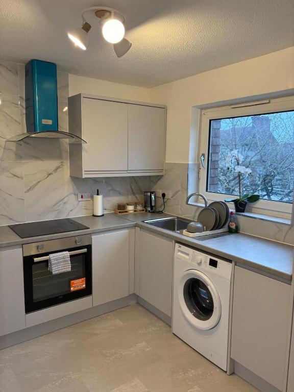 a kitchen with a sink and a washing machine at Jay3 Suites - Spacious Entire Apartment in London in Dagenham