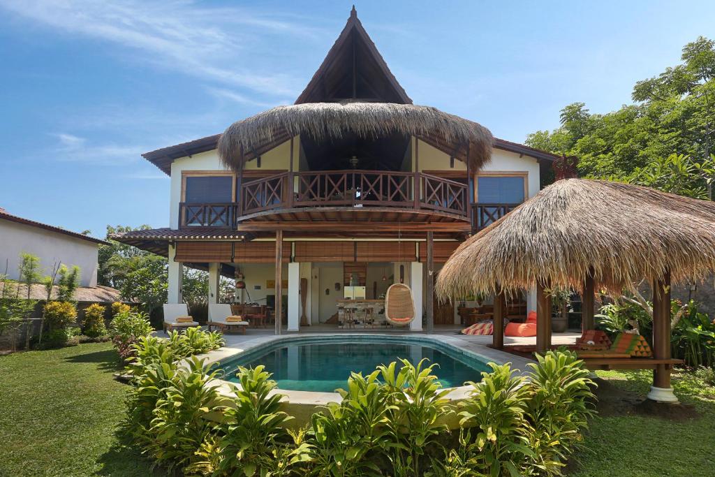 a villa with a swimming pool and a house at Breezy Point Villas in Nusa Dua