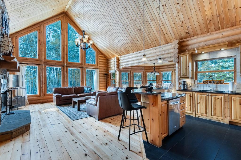 a kitchen and living room in a log cabin at Fiddler Lake Resort - Deer 76 in Mille-Isles