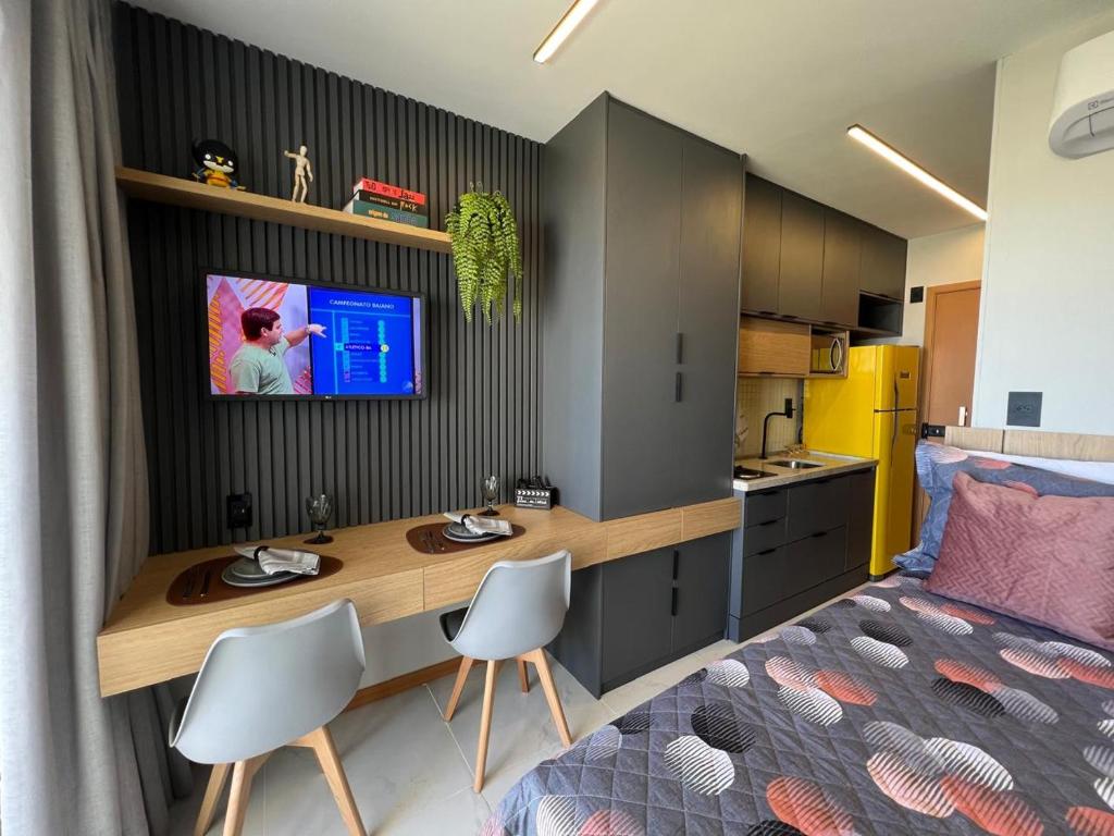 a bedroom with a desk and a bed and a kitchen at Studio TEC Centro de convenções Smart Home in Salvador