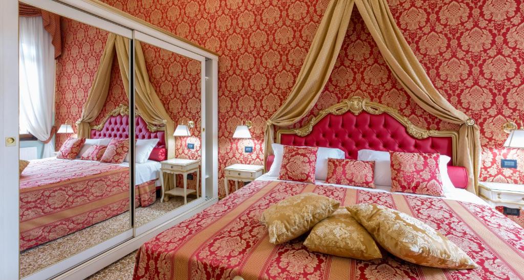 a pink bedroom with two beds and mirrors at Luxury Suites in Venice-Friendly Venice Suites in Venice