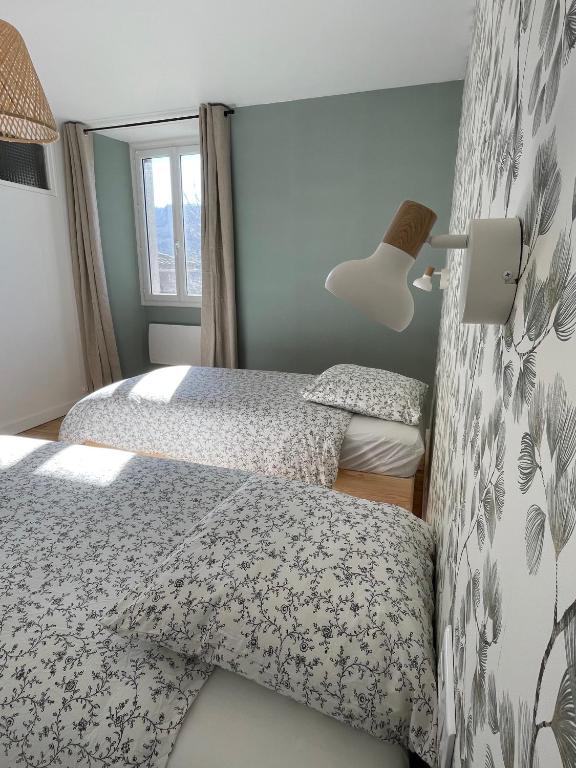 una camera con 2 letti e una lampada di Lili-Belle, maison de vacances a Livinhac-le-Haut
