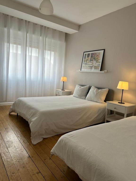 2 camas en una habitación blanca con 2 lámparas en Hyper Centre Krutenau Étoile Bourse Appart, en Estrasburgo