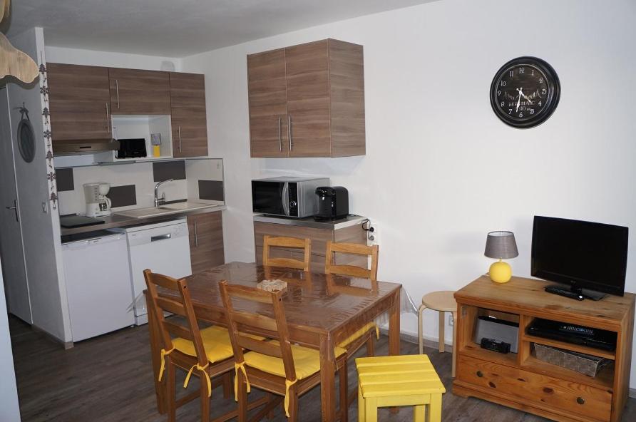 une cuisine avec une table et des chaises en bois et une cuisine avec une table dans l'établissement Verseau Flaine Forêt, à Arâches-la-Frasse