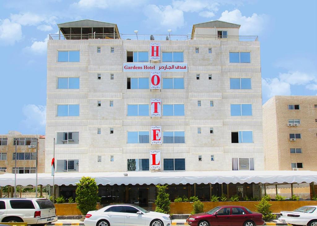 a hotel building with cars parked in front of it at Gardens Hotel in Amman