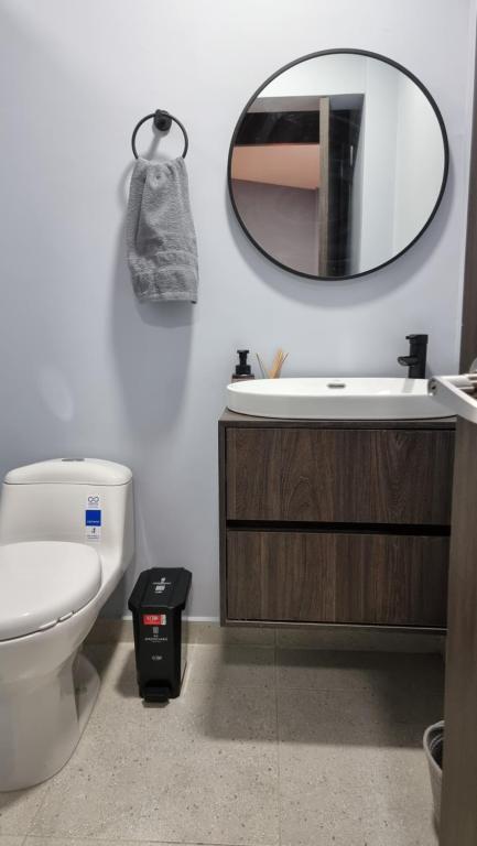 baño con aseo y espejo en la pared en Casa 1982, en Manizales