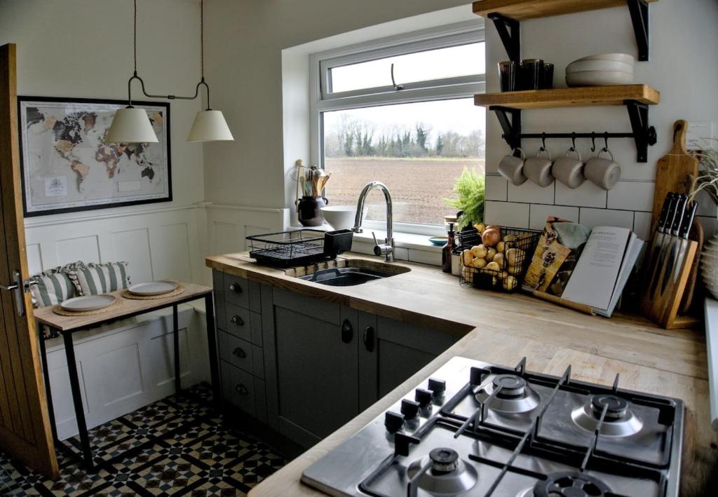una cucina con fornelli, lavello e finestra di Stylish Cottage near York a Rawcliffe