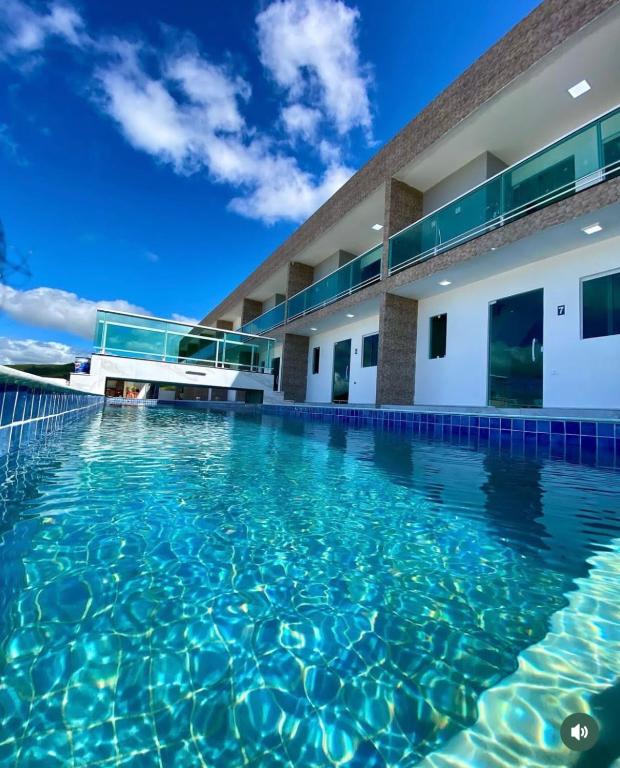 a swimming pool in front of a building at Excelente Flat no alto de Bezerros in Bezerros
