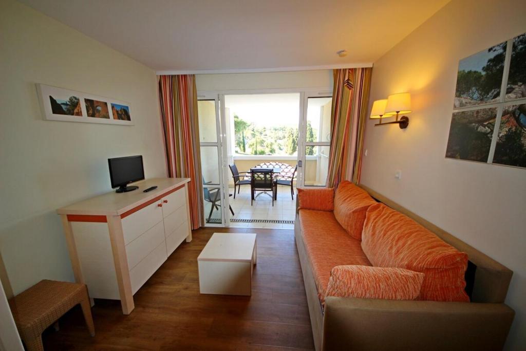 - un salon avec un canapé orange et un bureau dans l'établissement Un coin de paradis à Cap Esterel, à Saint-Raphaël