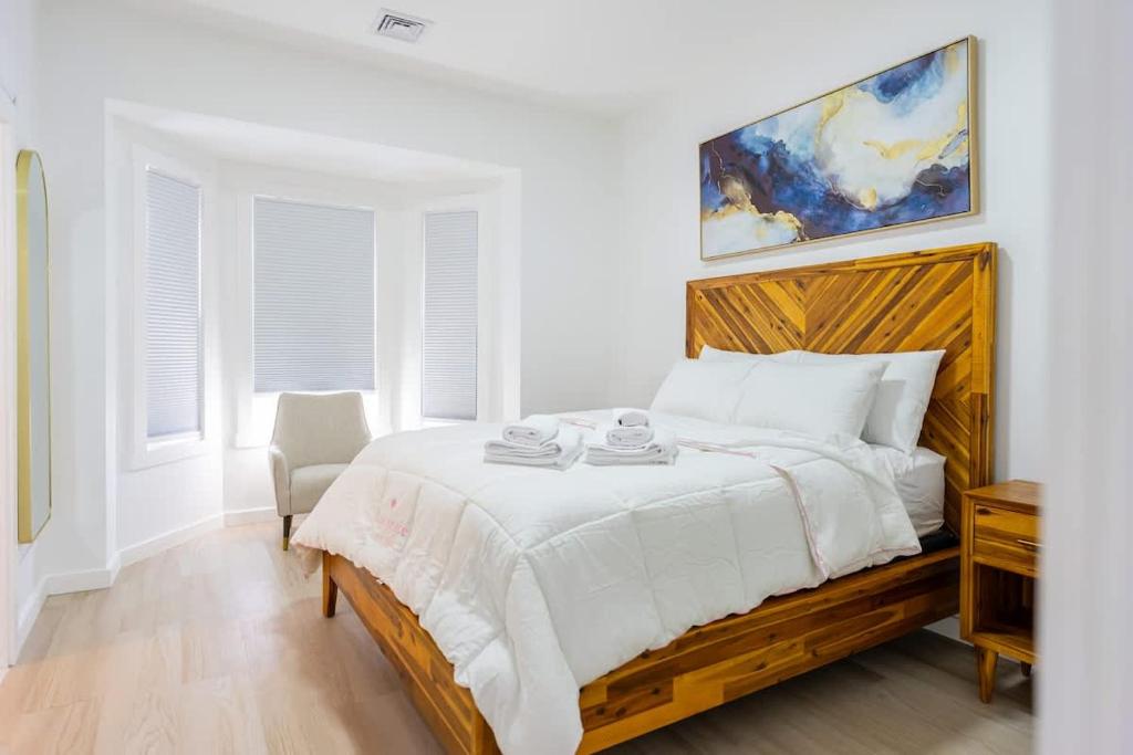 Un dormitorio blanco con una cama grande con cabecero de madera. en Luxury 2 Bed 2 Bath East Boston, en Boston
