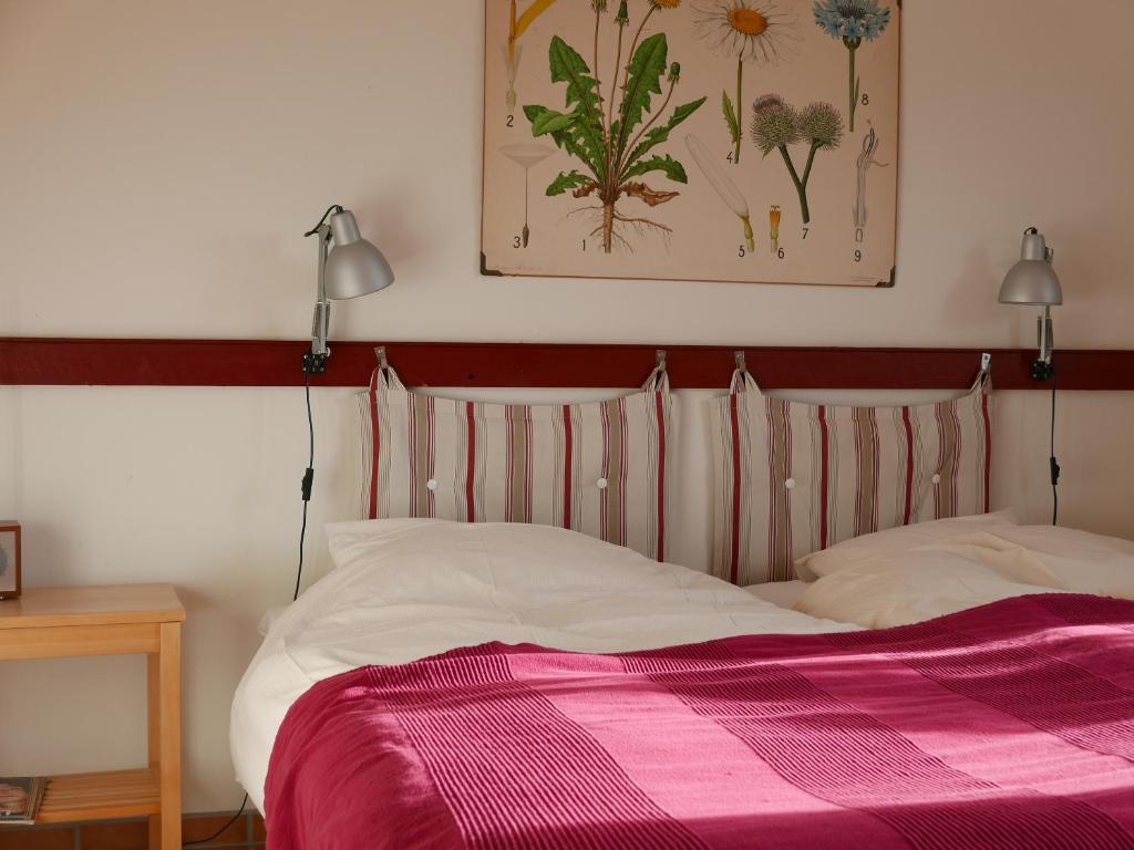 a bedroom with a bed with a pink blanket at Lekanders Bär & Boende in Tyfta