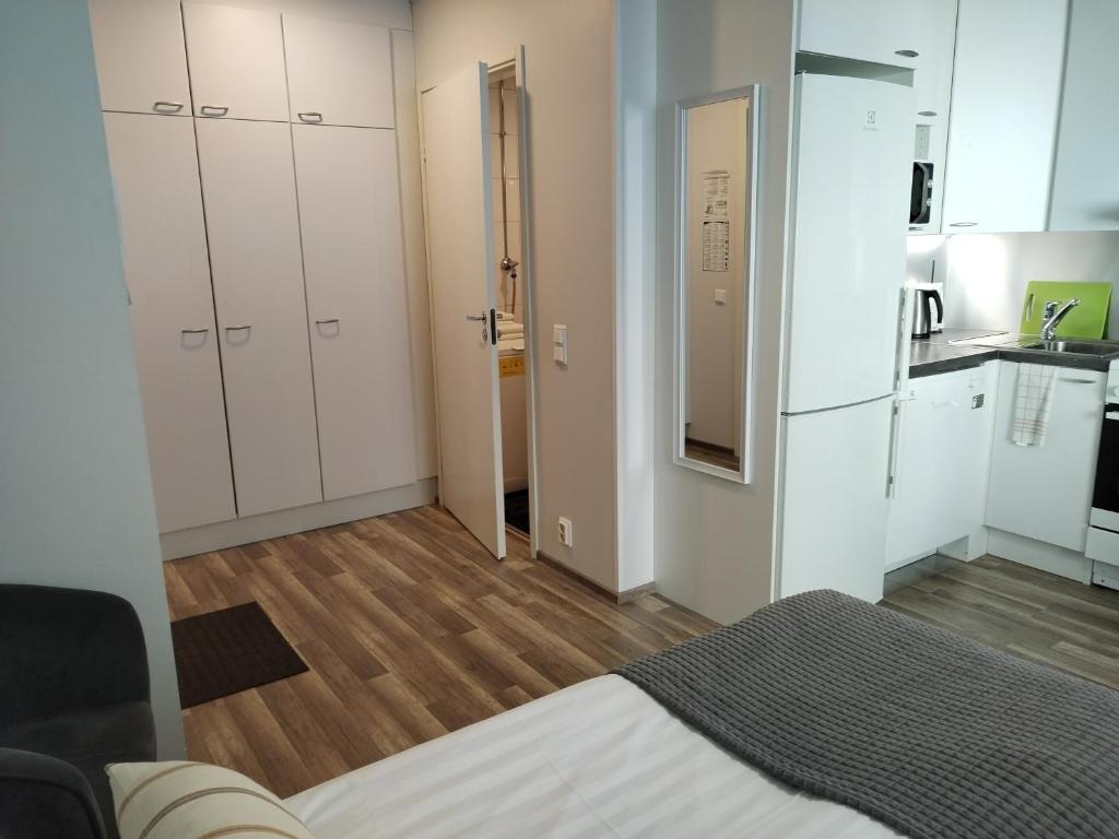 a small kitchen with white cabinets and a kitchenette with a kitchen at Väinö Apartment 10 in Jyväskylä