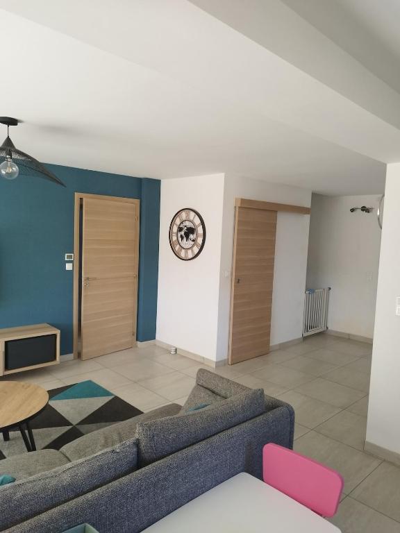 un salon avec un canapé et une horloge au mur dans l'établissement Villa à louer 12 personnes - Le Muy, au Muy