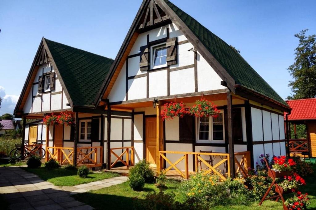 a black and white house with a green roof at Skrawek Nieba in Dąbki