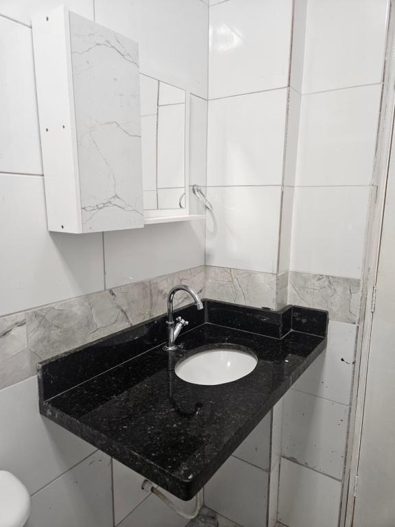 a bathroom with a sink and a mirror at Apartamento para aproveitar a praia in Praia Grande