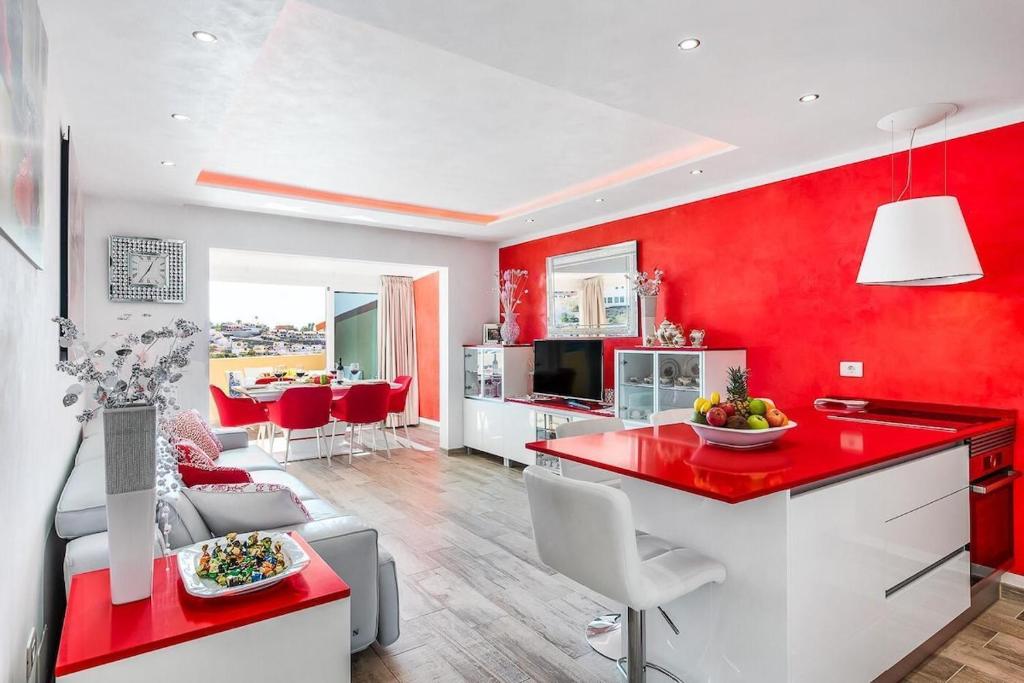 a red kitchen and living room with a red wall at Ines Luxury Costa Adeje in Adeje