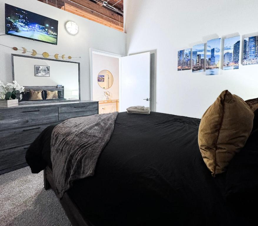a bedroom with a black bed and a large mirror at Luxéry Stay Chicago - Themed Units! Close to Downtown, McCormick Place & Wintrust Arena in Chicago