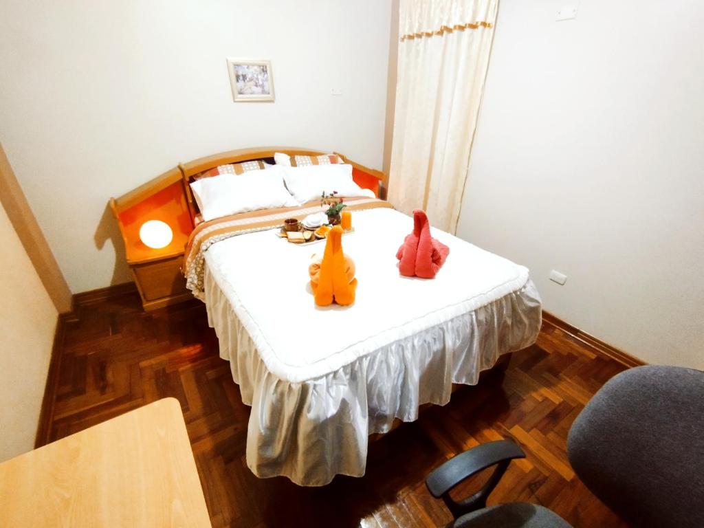a bedroom with a bed with two stuffed animals on it at Residencia en Gourmancia - Estancia & Sabor in Puno