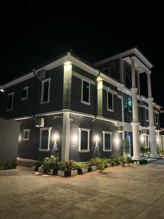 a large black house with white columns and lights at Grand T Abode Luxury Apartment in Ibadan