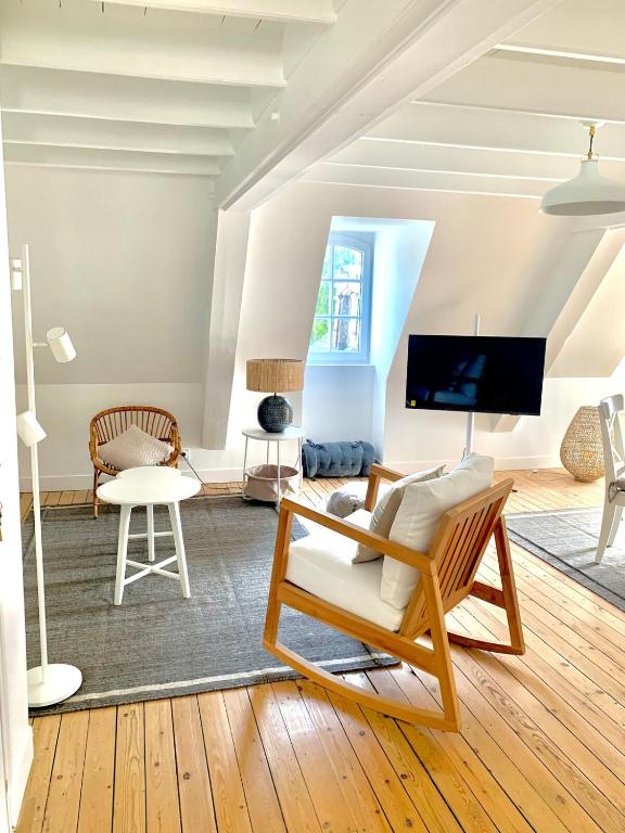 un salon avec une chaise et une télévision dans l'établissement Charmant F2 Atypique Coutances centre, à Coutances