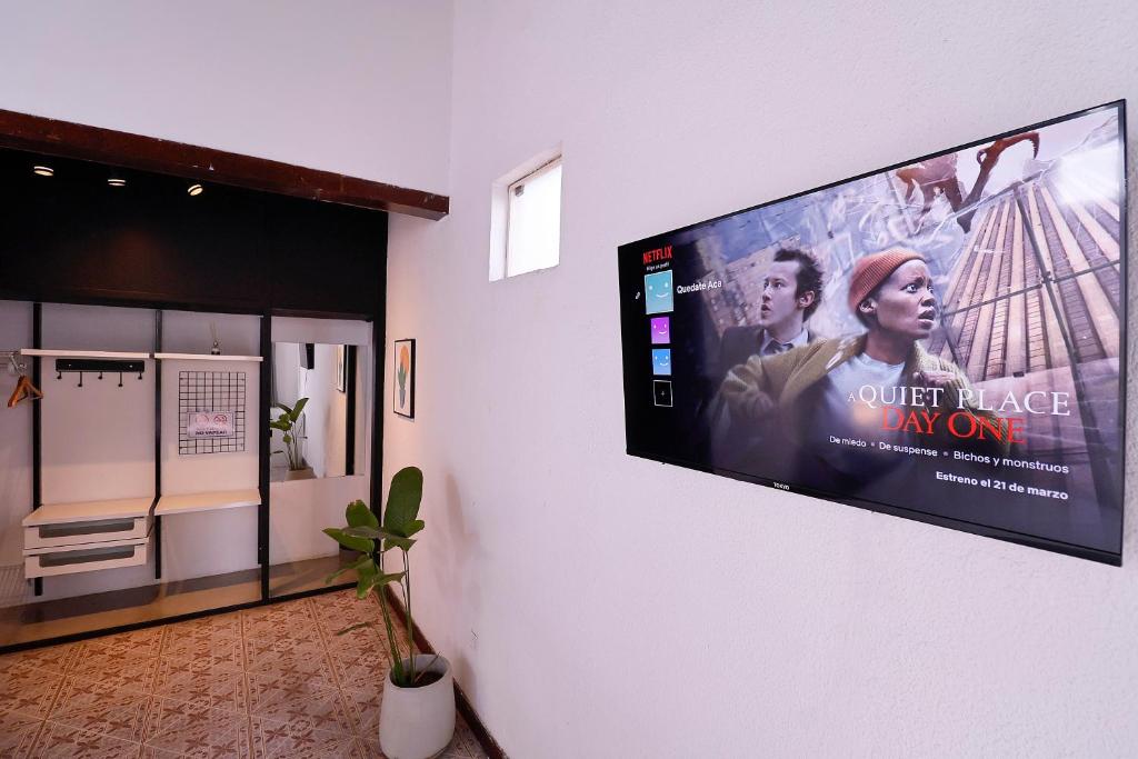 una TV a schermo piatto appesa a un muro di Habitación privada con terraza y WiFi rápido en el centro ad Asunción