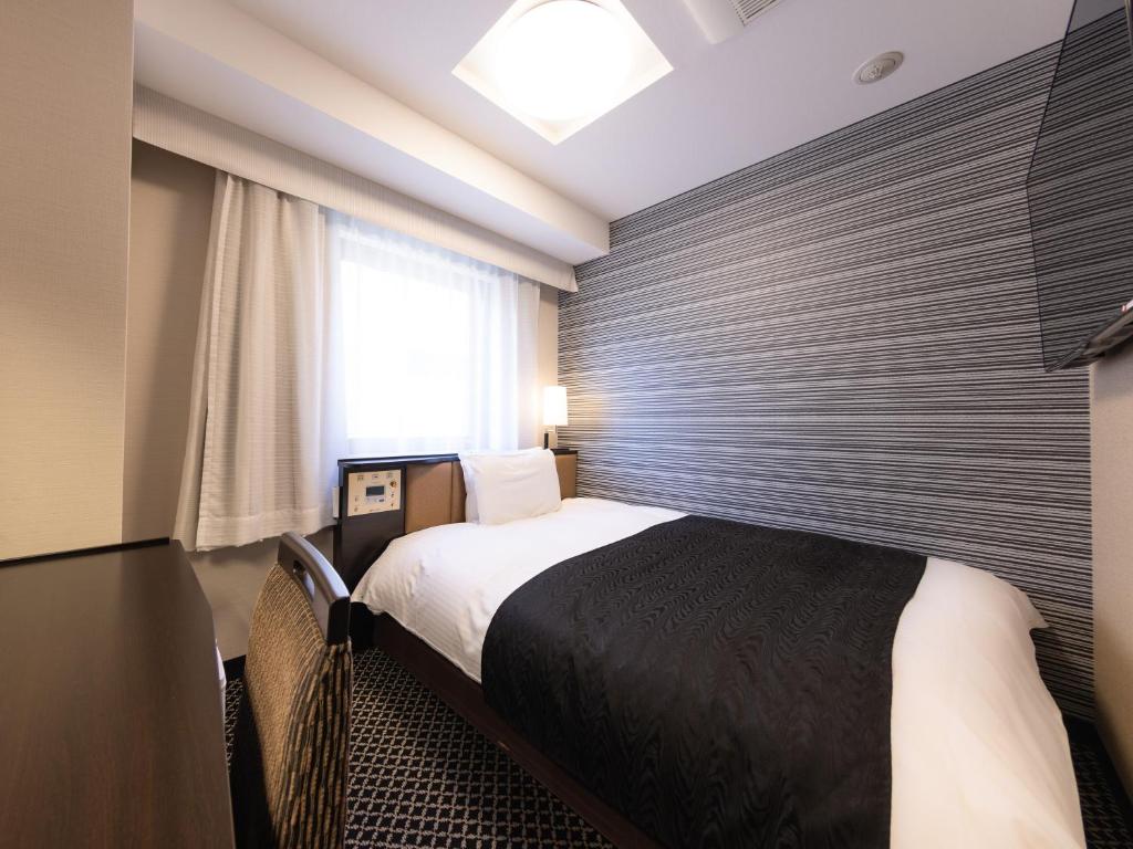 Postel nebo postele na pokoji v ubytování APA Hotel Ginza Shintomicho Ekimae Kita