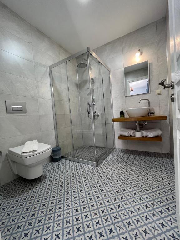 a bathroom with a shower and a toilet and a sink at Villa Veria in Çeşme