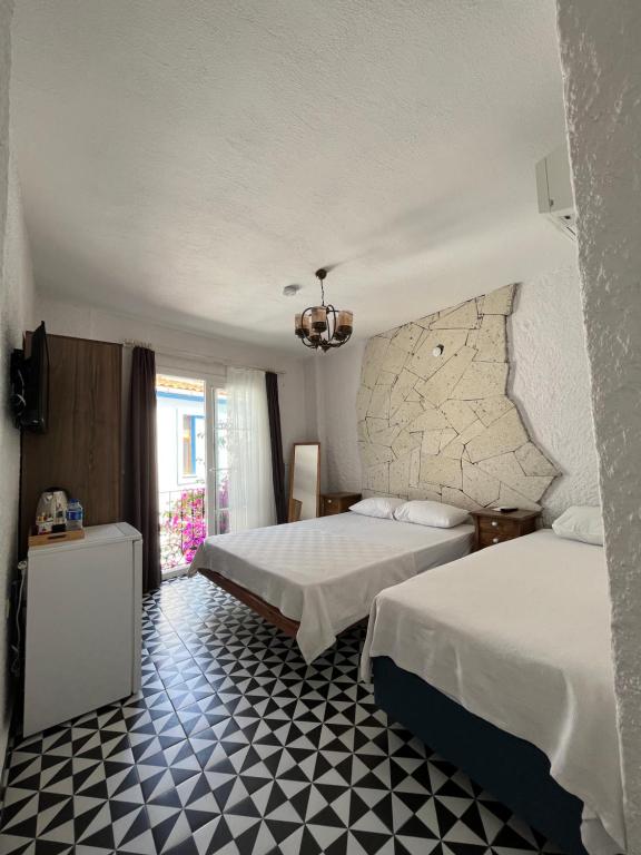 a bedroom with two beds and a checkered floor at Villa Veria in Çeşme
