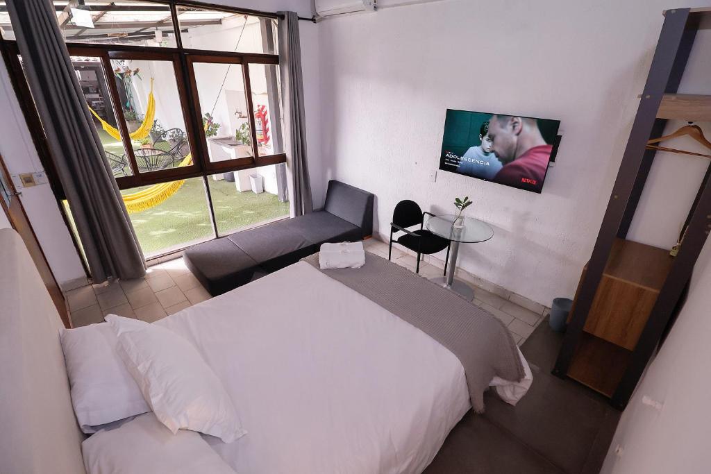 una camera con letto e TV a parete di Habitación privada con terraza y WiFi rápido en el centro ad Asunción