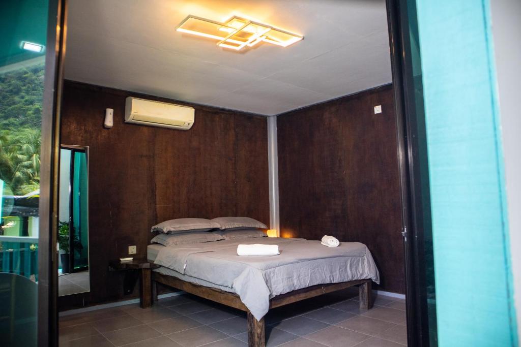 a bedroom with a bed and a mirror at Pondok Beach Shack in Tioman Island