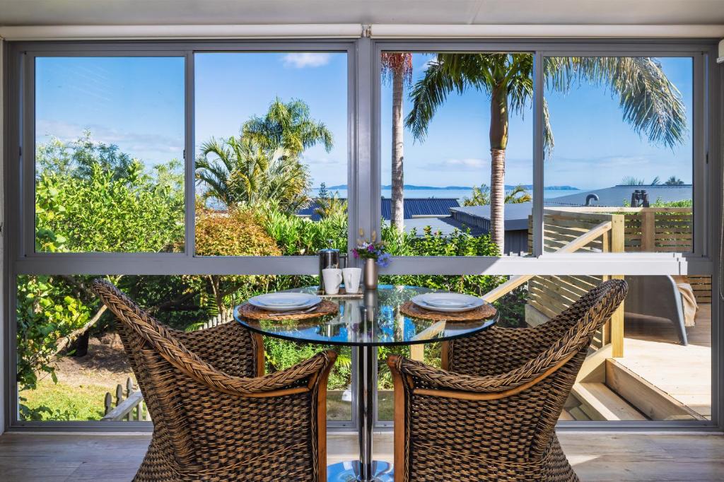 a glass table and chairs with a view of the ocean at Coopers Perch - Coopers Beach Couples Retreat in Coopers Beach
