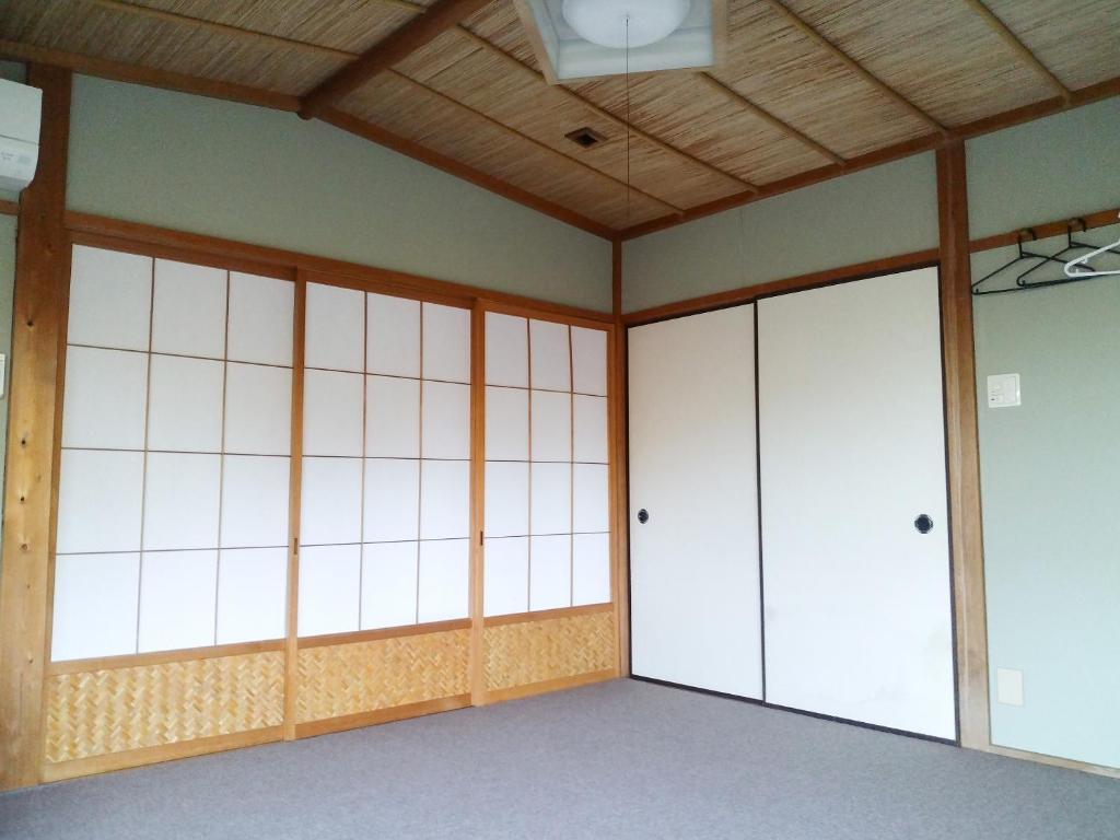 宮津市にあるコテージ自給自足世屋高原の白い壁と木製の天井の空き部屋