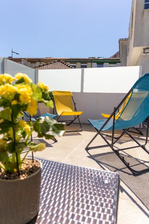 three chairs and a potted plant on a roof at Douro Garden and Rooftop Home 1 in Vila Nova de Gaia
