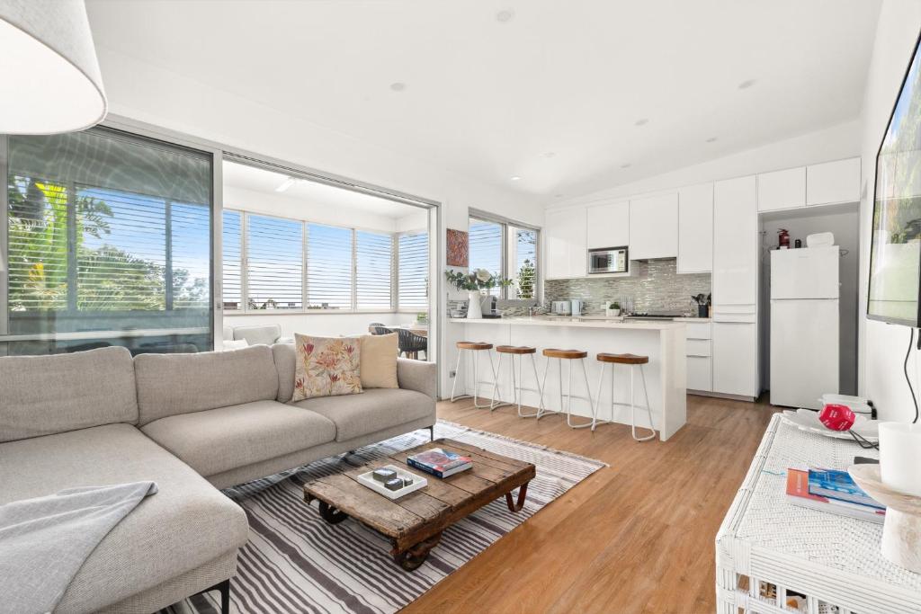a living room with a couch and a table at Luxury 2-Bed with Ocean Views and Garden in Collaroy