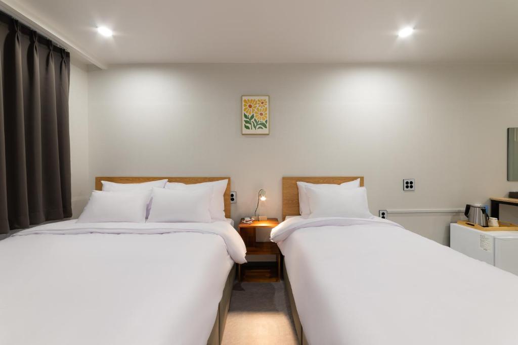 two beds sitting next to each other in a room at Stayz437 Jongno in Seoul
