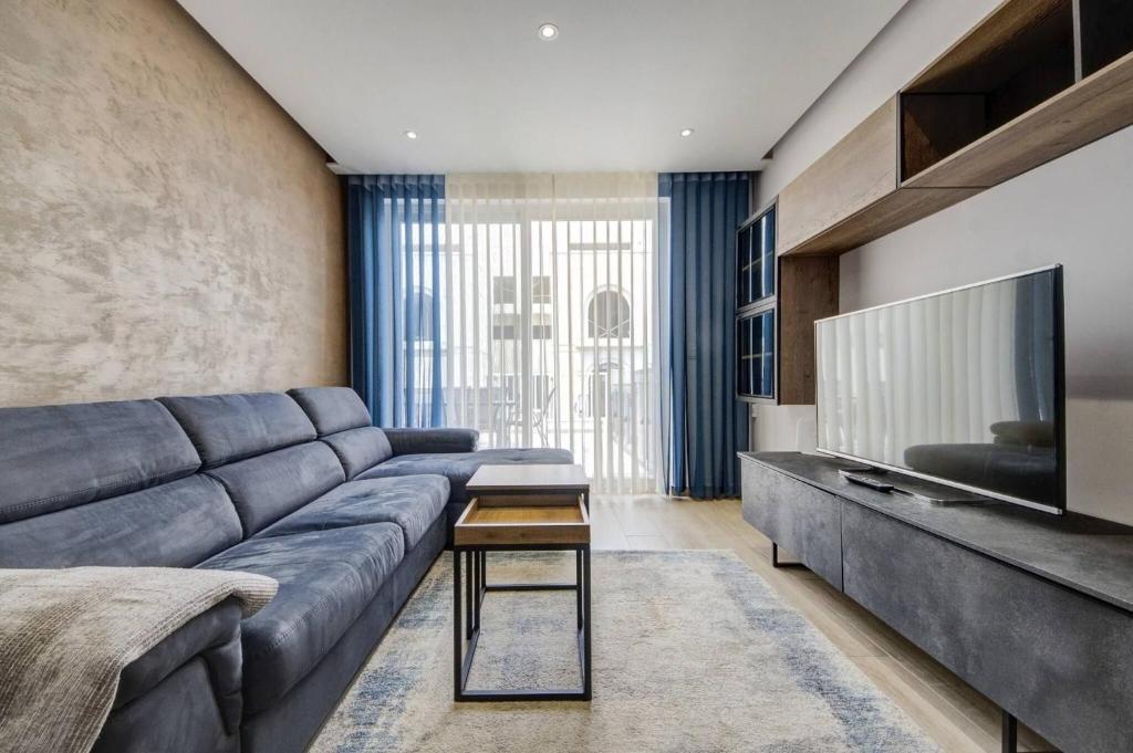 a living room with a couch and a television at Beautiful 2 BDR Penthouse near Valletta sleeps 6 in Il-Ħamra