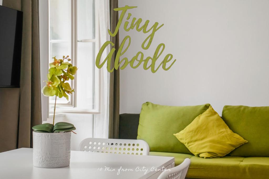 ein Wohnzimmer mit einem grünen Sofa und einem Tisch in der Unterkunft Comfortable 2BR Apt Central & Well Connected in Wien
