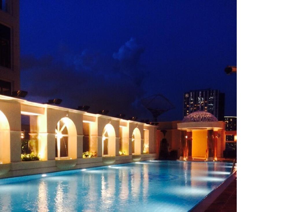 una grande piscina in un edificio di notte di The Royal Garden a Hong Kong