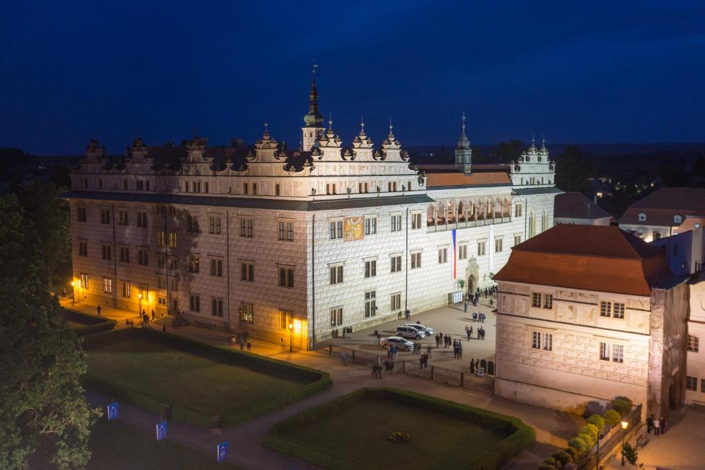 um grande edifício branco com um pátio à noite em Zámecké apartmány Litomyšl em Litomysl