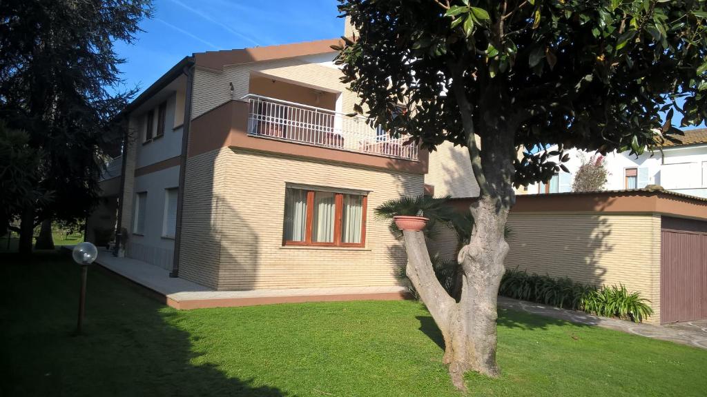 a house with a tree in front of it at Villa Gisi Guest House in Fiumicino
